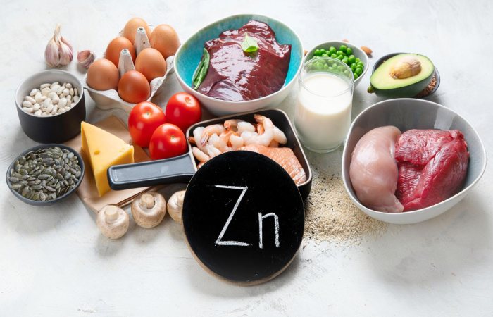 Testosterone-boosting foods including salmon, eggs, avocados, nuts, and leafy greens rich in healthy fats and zinc